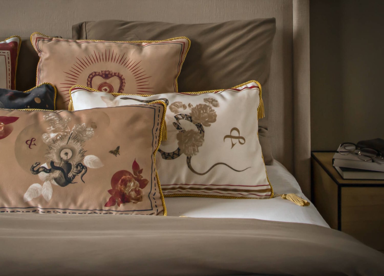 łóżko w sypialni z dużą ilością stylowych poduszek dekoracyjnych