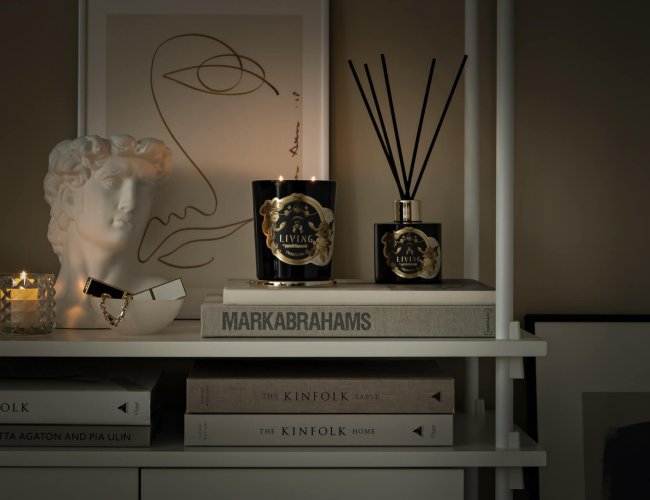 zestaw eleganckiej czarnej świecy ze złotą pokrywką i dyfuzorem zapachowym z pałeczkami w artystycznej aranżacji